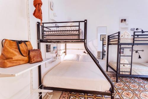 a room with two bunk beds and a purse at Granny's Inn Hostel in Sliema