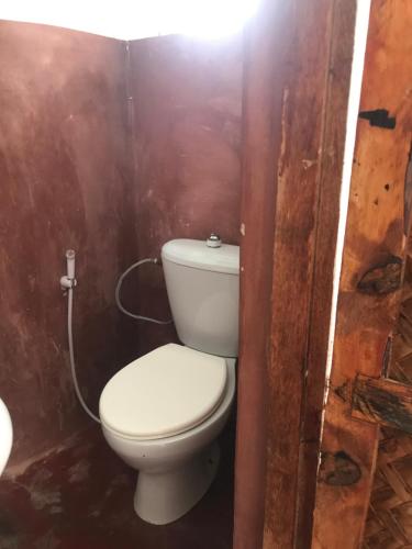 a bathroom with a toilet in a wooden wall at Moringe Home Stay - Village House in Jambiani