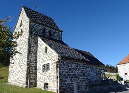 an old stone church with a black roof at Apartment Almberg in Mitterfirmiansreut