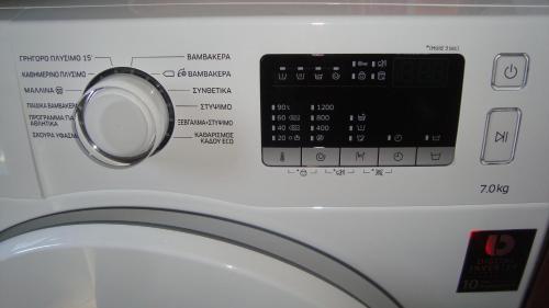 een afsluitbare wasmachine met een klok bij Sole Mio in Milína