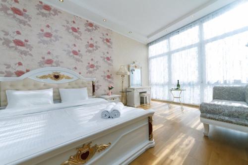 キーウにあるPanoramic luxury apartments with Jacuzzi Obolonskaya embankmentの花柄の壁紙を用いた白いベッド付きのベッドルーム1室