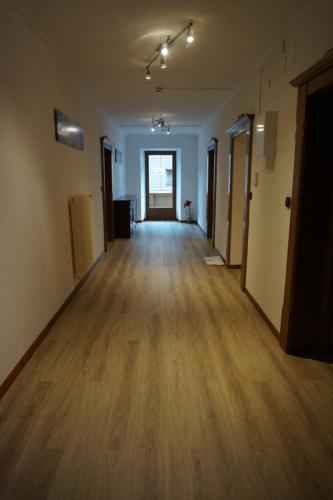 an empty room with a hard wood floor and a hallway at Hotel Untermetzger in Zell am Ziller