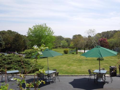 a group of tables and chairs with green umbrellas at Hamlet Inn in Southampton