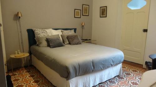 une chambre avec un lit avec des oreillers dessus dans l'établissement Chambre côté jardin, à Nîmes