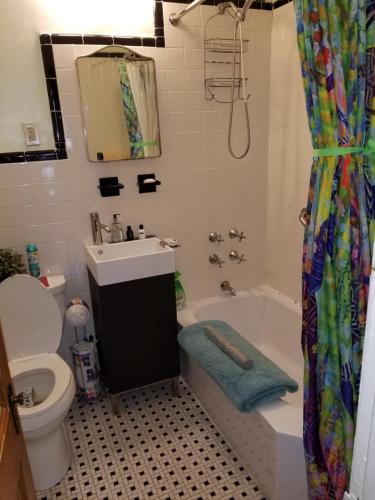 La salle de bains est pourvue d'un lavabo, d'une baignoire et de toilettes. dans l'établissement Cozy Fully Furnished Apartment Near Prospect Park & Public Transport, à Brooklyn