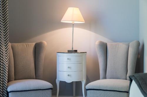 two chairs sitting next to a dresser and a lamp at I Mori di Porta Nuova Suite & Terrace in Palermo