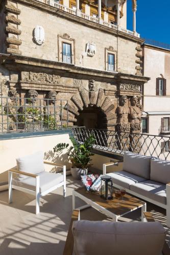 a patio with white furniture in front of a building at I Mori di Porta Nuova Suite & Terrace in Palermo