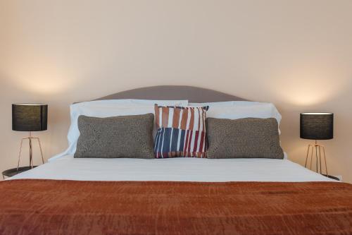 a bedroom with a bed with two lamps on it at I Mori di Porta Nuova Suite & Terrace in Palermo