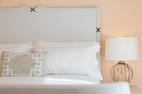 a bed with white pillows and a lamp at I Mori di Porta Nuova Suite & Terrace in Palermo