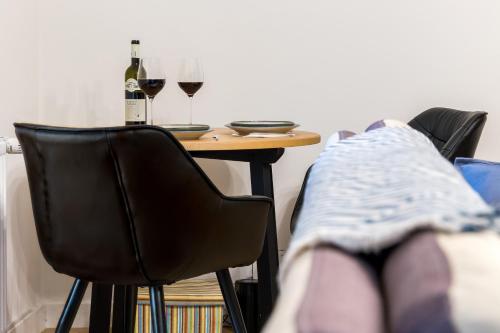 a table with two glasses of wine and a person laying on a bed at Squirrel Apartment in Bucharest
