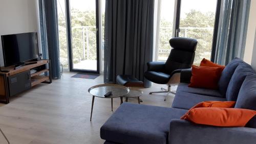 uma sala de estar com um sofá azul e uma televisão em Ferienwohnung Albatros em Binz