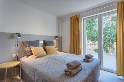 a bedroom with a bed with towels on it at Casa Mia Apartments in Premantura