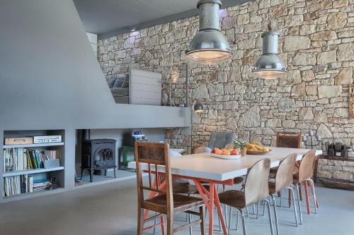 a dining room with a table and chairs and a stone wall at Casa Mia Apartments in Premantura