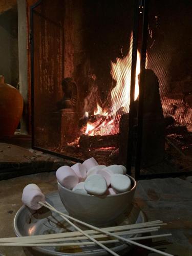 a bowl of marshmallows in front of a fire at Chambre d'hotes Ferme de la Forlonge in Sauvigny-le-Beuréal