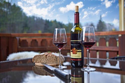 two glasses of red wine and a bottle of bread at Apartmán ENZO č 103 Tále Chopok Juh in Tale