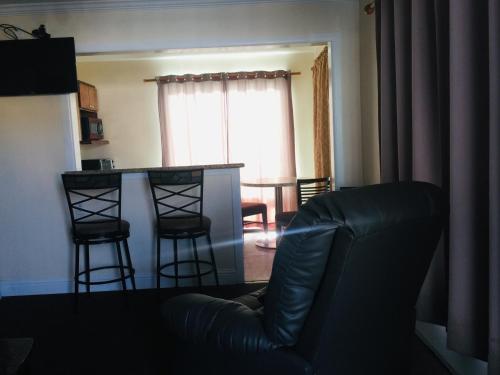 a living room with a couch and a table and chairs at Dolphin Cove Motel in Pismo Beach