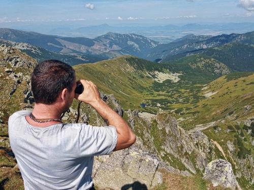 a man taking a picture of a mountain at Apartmán ENZO č 103 Tále Chopok Juh in Tale