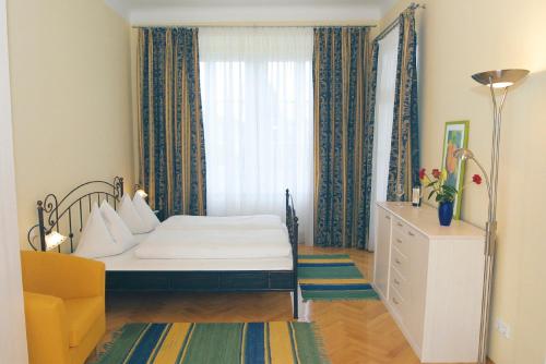 ein kleines Schlafzimmer mit einem Bett und einem Fenster in der Unterkunft Villa Engstler - Appartments in Velden am Wörthersee