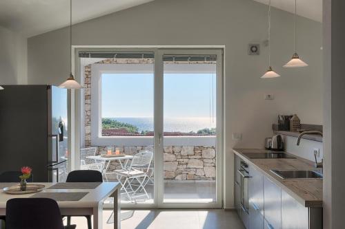 a kitchen with a large sliding glass door with a view of the ocean at Casa Mia Apartments in Premantura