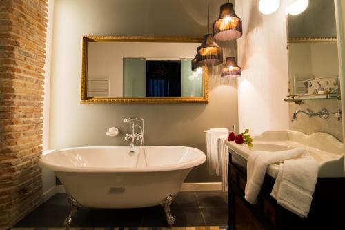 La salle de bains est pourvue d'une baignoire, d'un lavabo et d'un miroir. dans l'établissement Casa rural El Ralenco, à Lécera