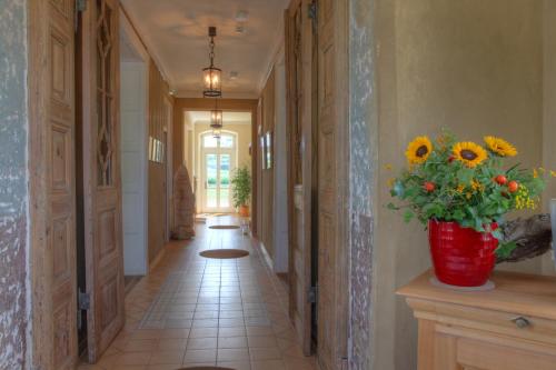 a hallway with a vase of sunflowers on the wall at Hotel Gutshaus Parin - Bio- und Gesundheitshotel in Parin