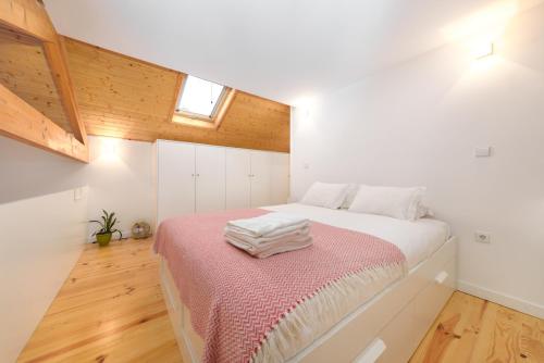 波多的住宿－Skylight Apartment，卧室配有白色床和粉色毯子