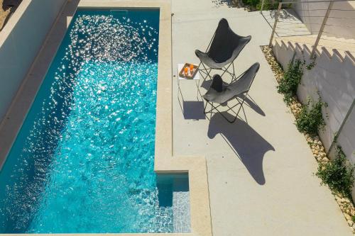 two chairs sitting next to a swimming pool at Casa Mia Apartments in Premantura