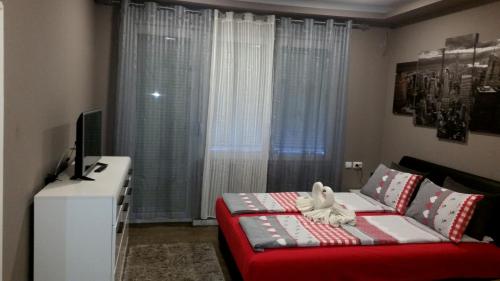 a small room with a bed and a television at Ceca Apartman in Niš
