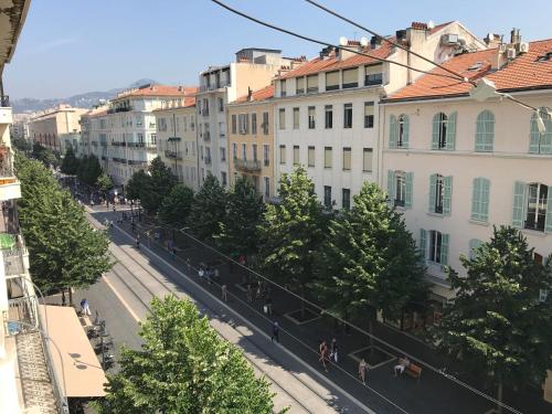 a group of people walking down a city street at Rigoletto Massena in Nice