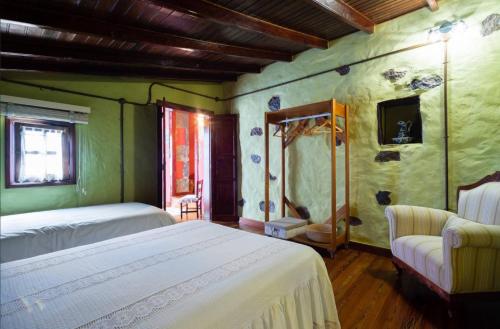 1 dormitorio con cama, sofá y TV en La Cuadra, en Firgas