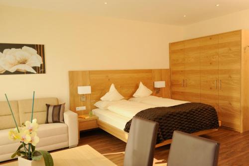 a hotel room with a bed and a table and chairs at Apartment Hotel Christine in Avelengo