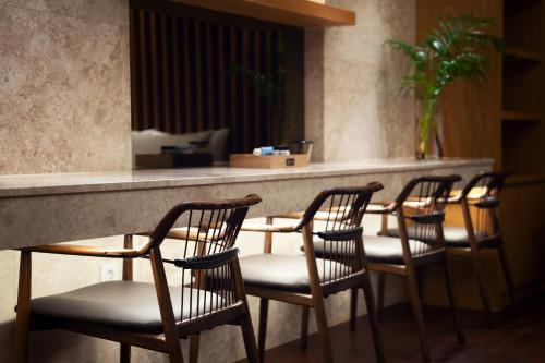 a group of chairs sitting at a bar in a restaurant at Hotel Artheim in Gwangju