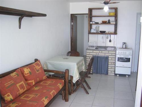 a living room with a table and a kitchen with a couch at Solar Dona Maria in Pinheira