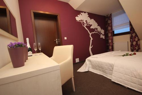a hotel room with a bed and a table with flowers at Biała Akacja Resort & Business in Prudnik