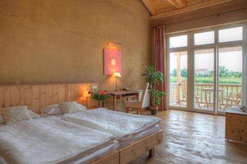 a bedroom with a large bed and a table at Hotel Gutshaus Parin - Bio- und Gesundheitshotel in Parin