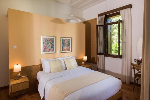 a bedroom with a large white bed and a window at Villa Filoxenia 1937 in Gerani Chanion