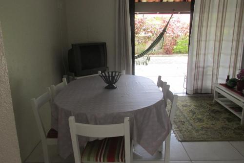 mesa de comedor con sillas blancas y TV en Sobrado Vila Branca, en Florianópolis