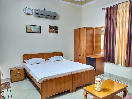 - une chambre avec un grand lit et une table dans l'établissement Ranthambore Tiger Home, à Sawai Madhopur