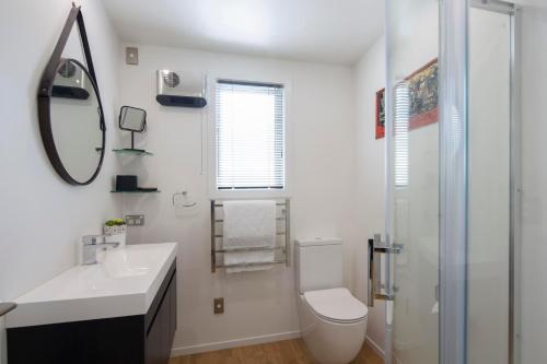 a bathroom with a toilet and a sink and a shower at Kohanga Rua Cottage by Amazing Accom in Queenstown