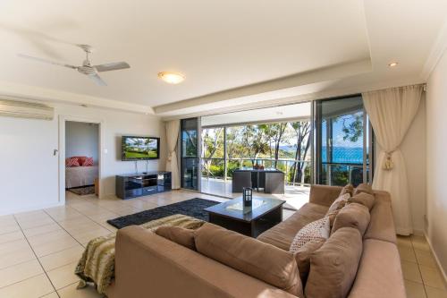 a living room with a couch and a tv at Blue Water Views on Hamilton Island by HIHA in Hamilton Island
