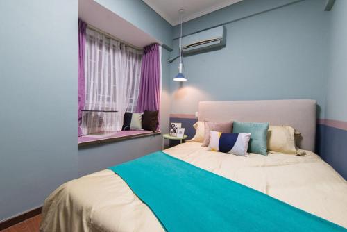 a bedroom with a large bed with blue walls and windows at Guangzhou Haizhu·Pearl Shadow Star City· Locals Apartment 00138600 in Guangzhou