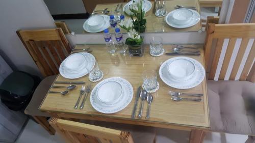une table en bois avec des assiettes et de l'argenterie dans l'établissement 101 Newport Boulevard C1, à Manille