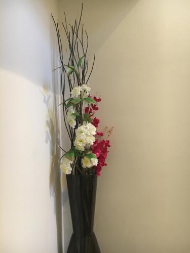 a black vase with red and white flowers in it at Cozy Rowhouse Next JHH in Baltimore
