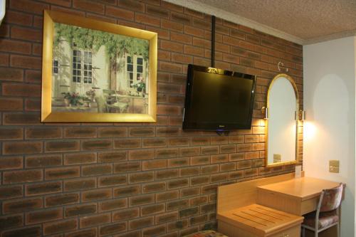 Arden Motel في ملبورن: جدار من الطوب مع شاشة تلفزيون مسطحة على جدار