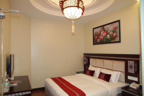 a hotel room with a bed and a chandelier at De Residence Hotel in Ipoh