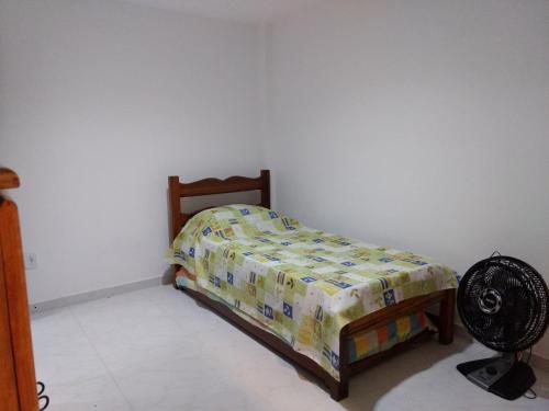 a small bedroom with a bed and a fan at Apartamento Novo em Itaúna, Maracanã do Surf in Saquarema