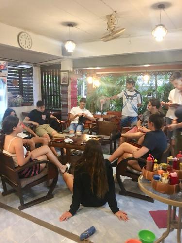 a group of people sitting in chairs in a room at TR Guesthouse in Sukhothai