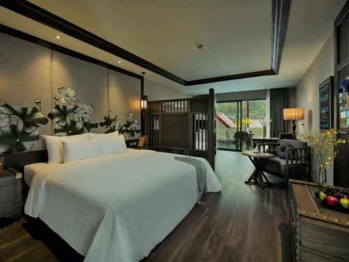 una camera con un grande letto bianco e un soggiorno di Lotus Aroma Sapa Hotel a Sa Pa