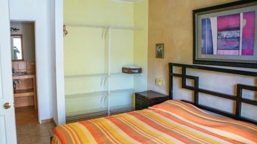 タマリンドにあるE14 Estrella Center of Tamarindo 3bed+2bathのベッドルーム1室(カラフルなストライプ毛布付きのベッド1台付)