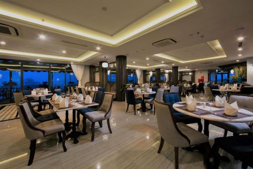 un ristorante con tavoli, sedie e finestre di Lotus Aroma Sapa Hotel a Sa Pa
